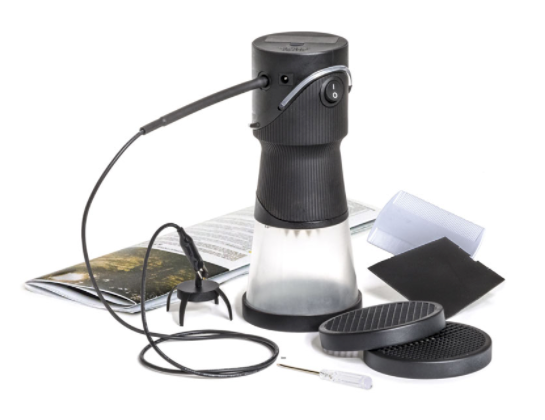 A model train accessory called Static King FS639, which is designed to create static grass on model train tracks. It has a black and gray color scheme, with a clear hopper and additional sieve sizes laid out next to it.